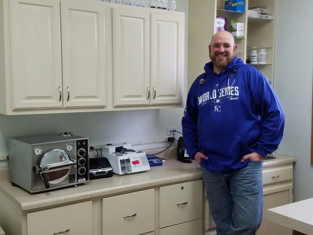 Dr. Vance Lassey in front of the pharmacy cabinets he built from a mismatched set. Courtesy Dr. Vance Lassey